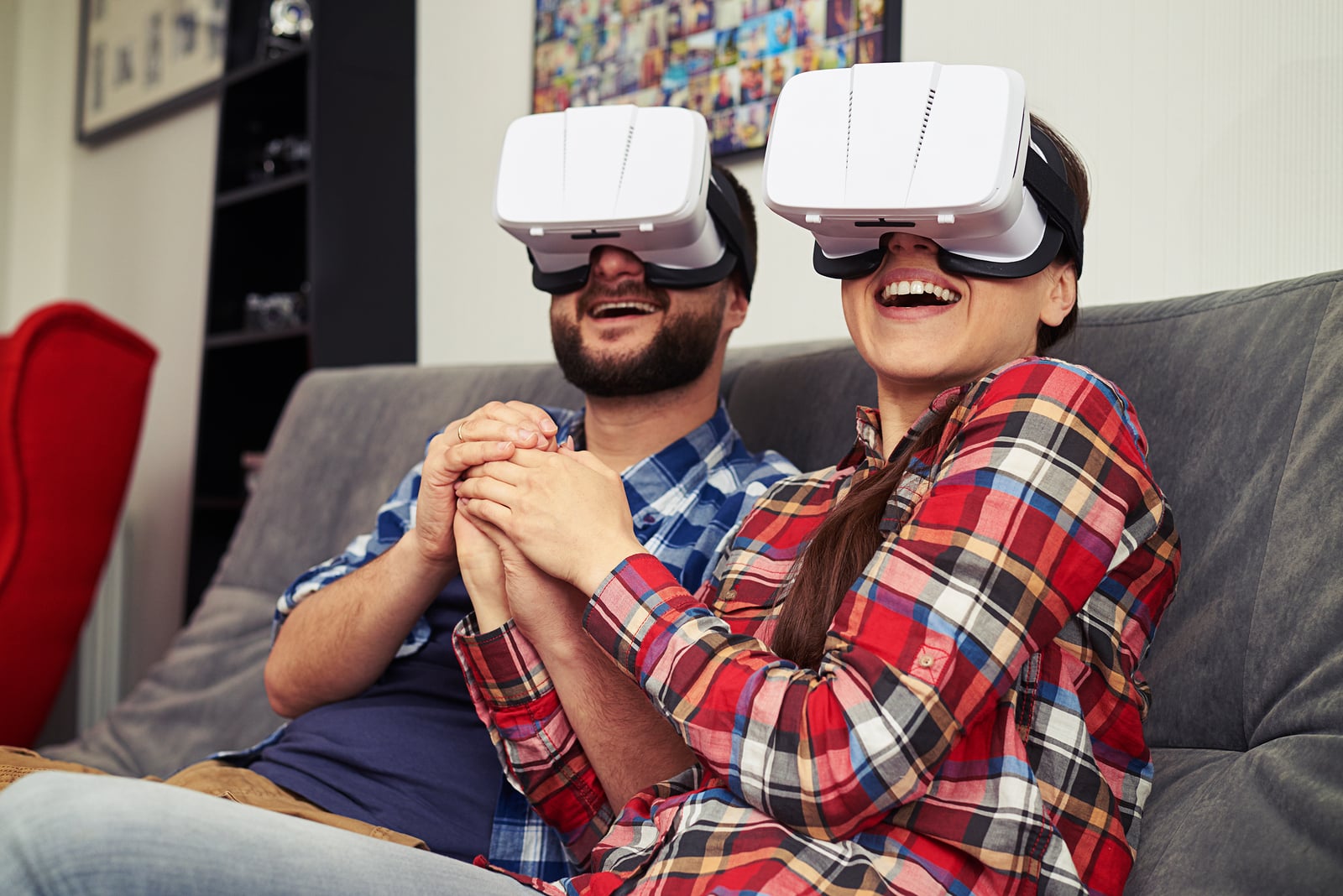 A young man and woman in casual clothes and virtual reality glasses is watching romantic movie