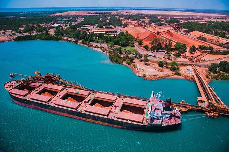 A ship is loaded with bauxite at a mining port.